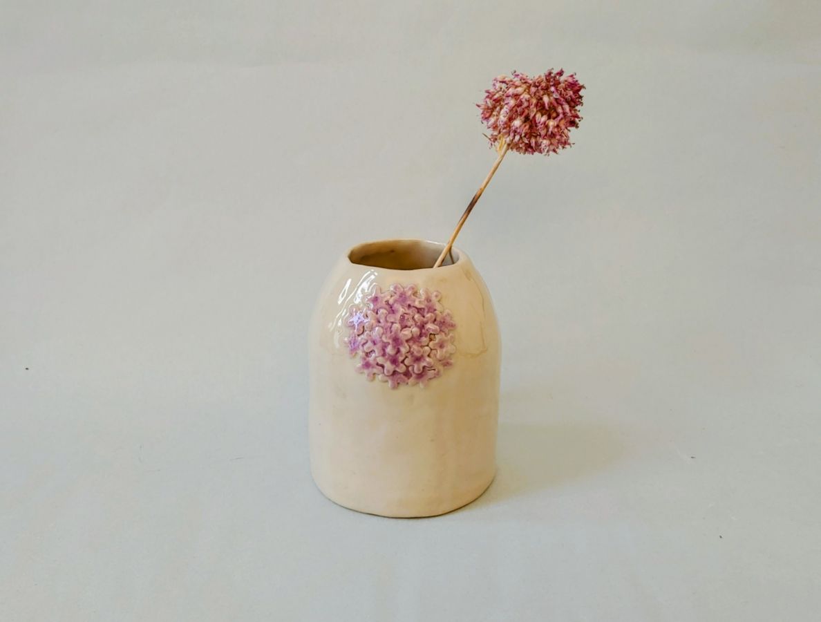 Natural ceramic vase with a delicate pale violet floral relief.”