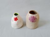 Natural ceramic vase with a delicate pale violet floral relief.”